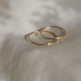 Handcrafted TALLULAH rings in 18k recycled gold on soft fabric, showcasing organic design from Basel, Switzerland.