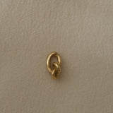 Close-up of a handcrafted link made from 18k recycled gold, showcasing a natural shiny surface, designed in Basel, Switzerland.