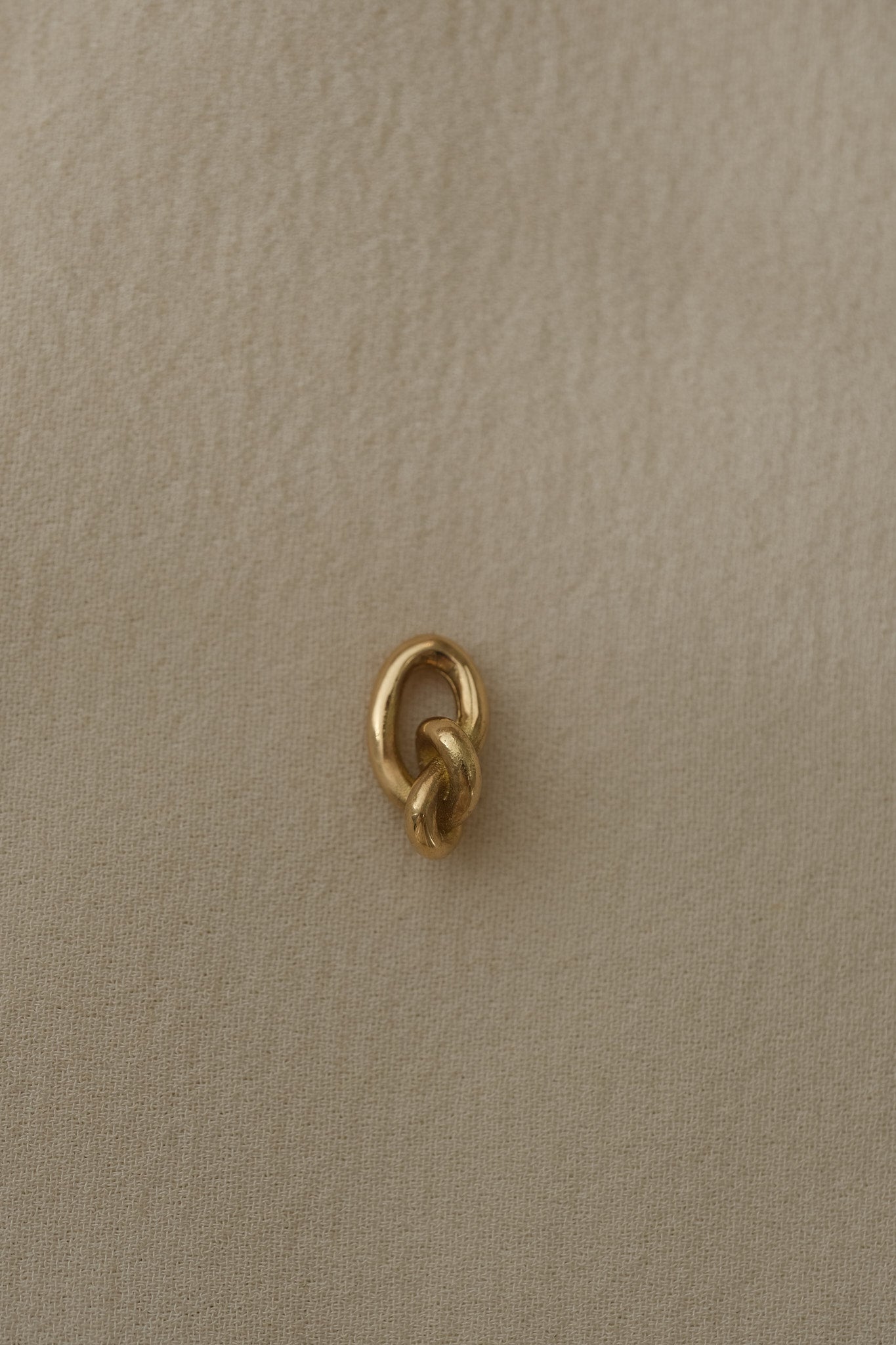 Close-up of a handcrafted link made from 18k recycled gold, showcasing a natural shiny surface, designed in Basel, Switzerland.