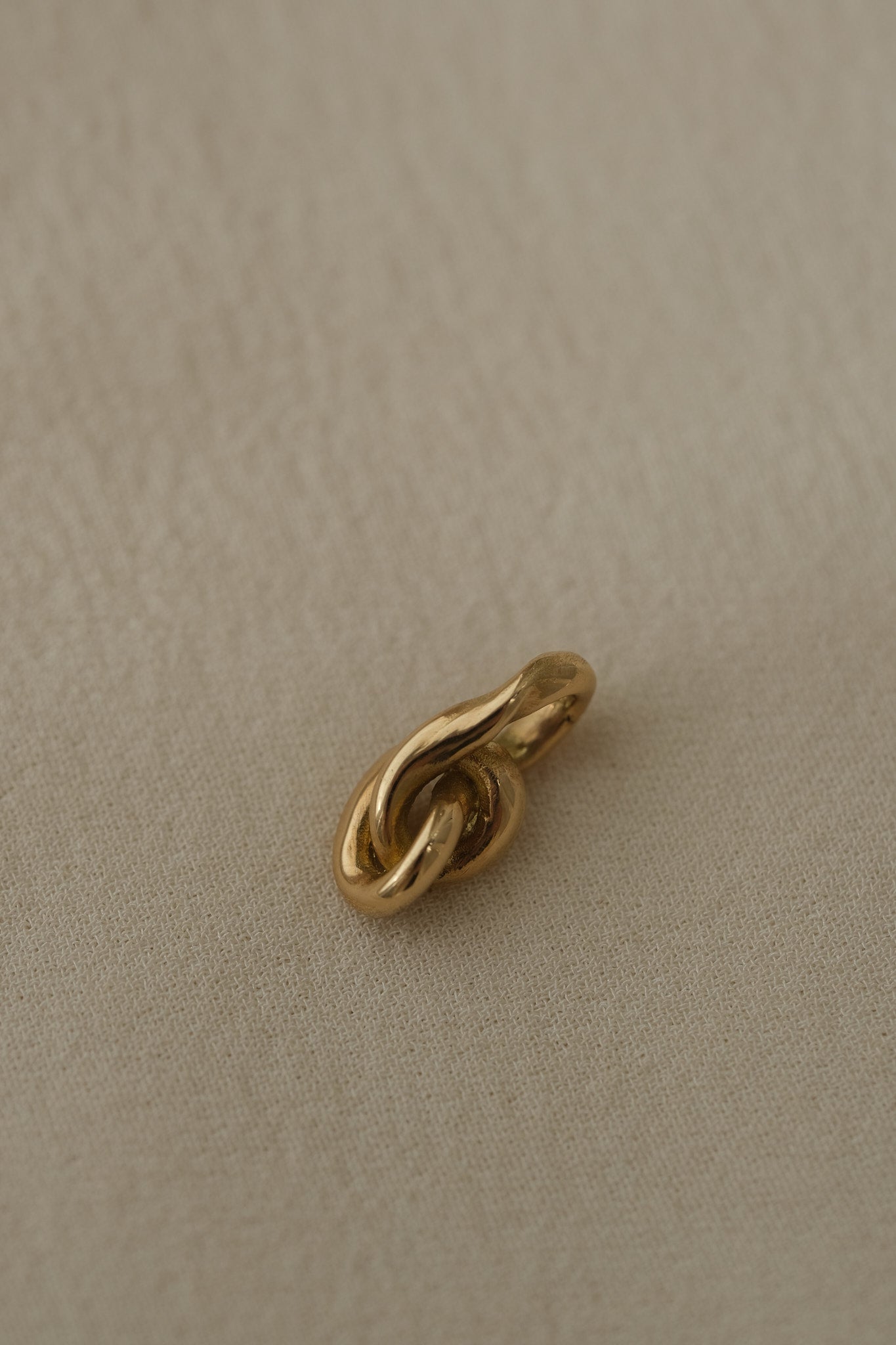 Handcrafted 18k recycled gold pendant from Basel, Switzerland with an organic design, featuring a shiny surface.