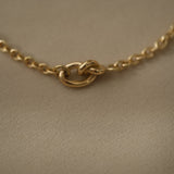 Close-up of a handcrafted 18k recycled gold bracelet clasp, featuring a shiny surface and organic design.