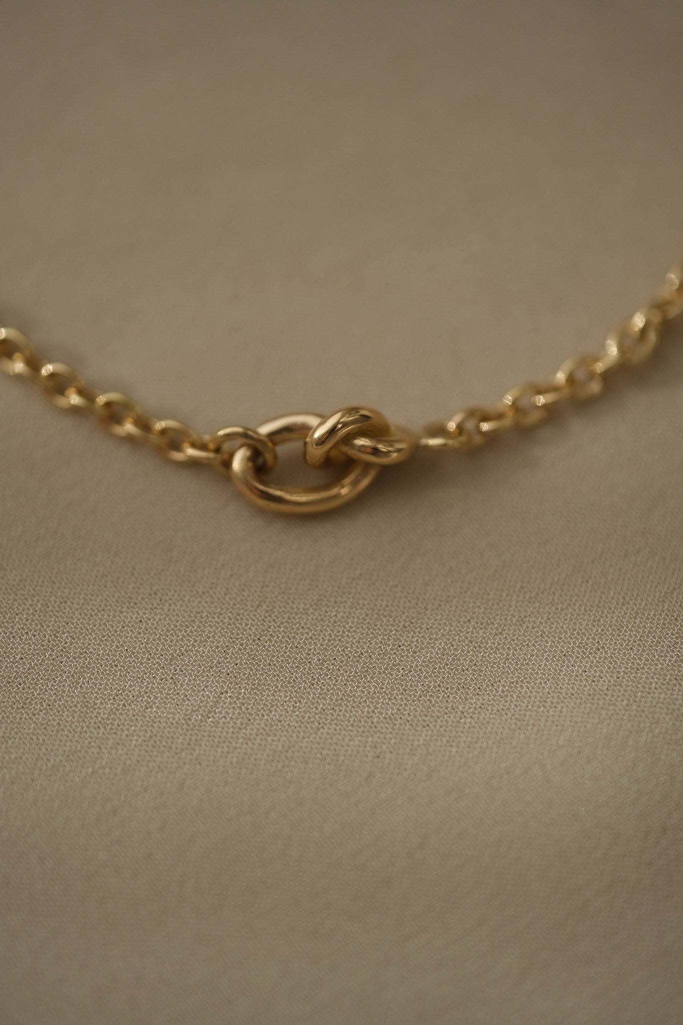 Close-up of a handcrafted 18k recycled gold bracelet clasp, featuring a shiny surface and organic design.