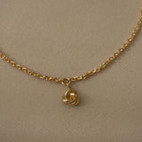 Handcrafted 18k recycled gold bracelet with a charm, designed in Basel, Switzerland, featuring a natural shiny surface.
