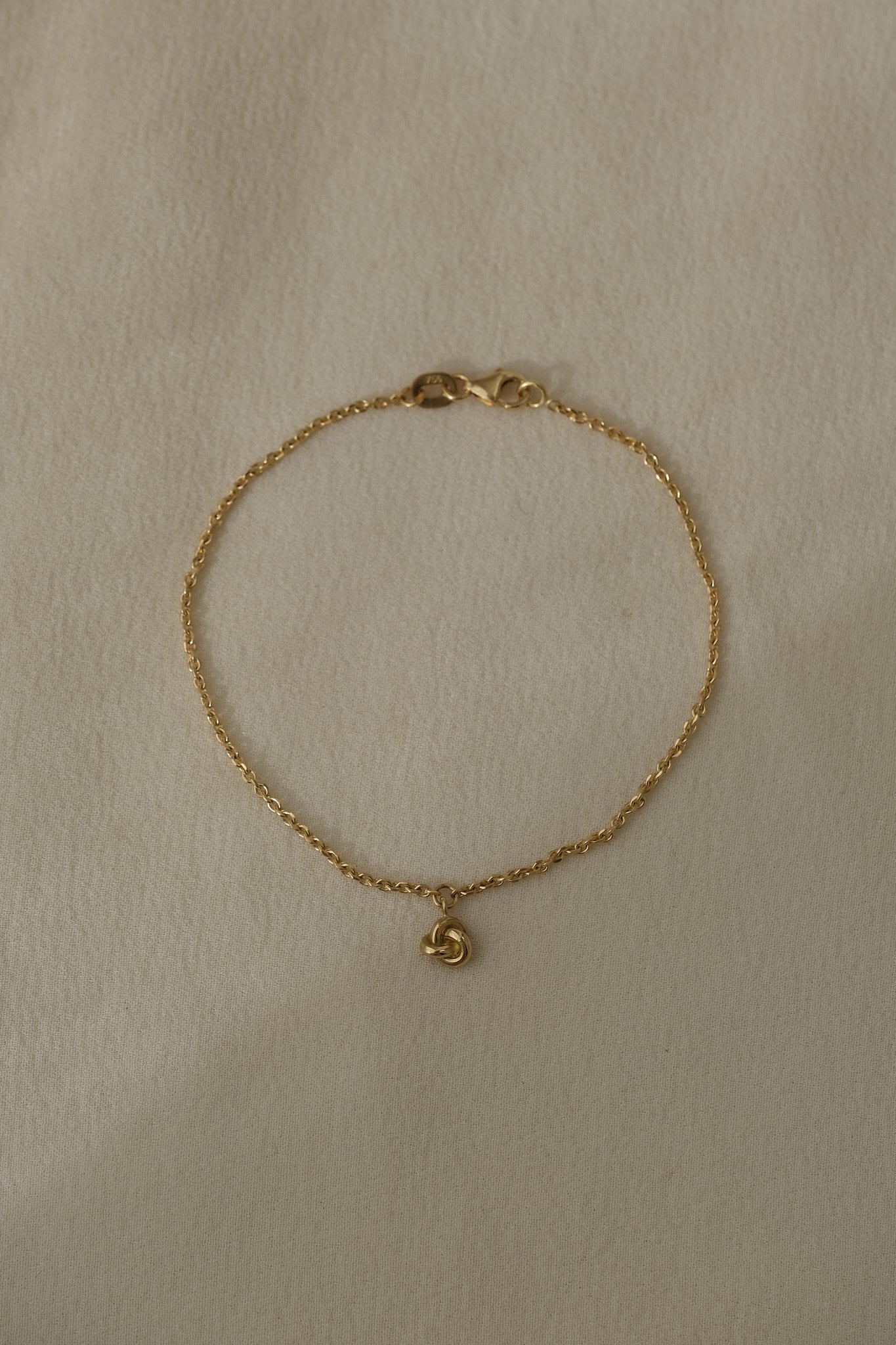 18k recycled gold bracelet with charm, handcrafted in Basel Switzerland, featuring a natural shiny surface.