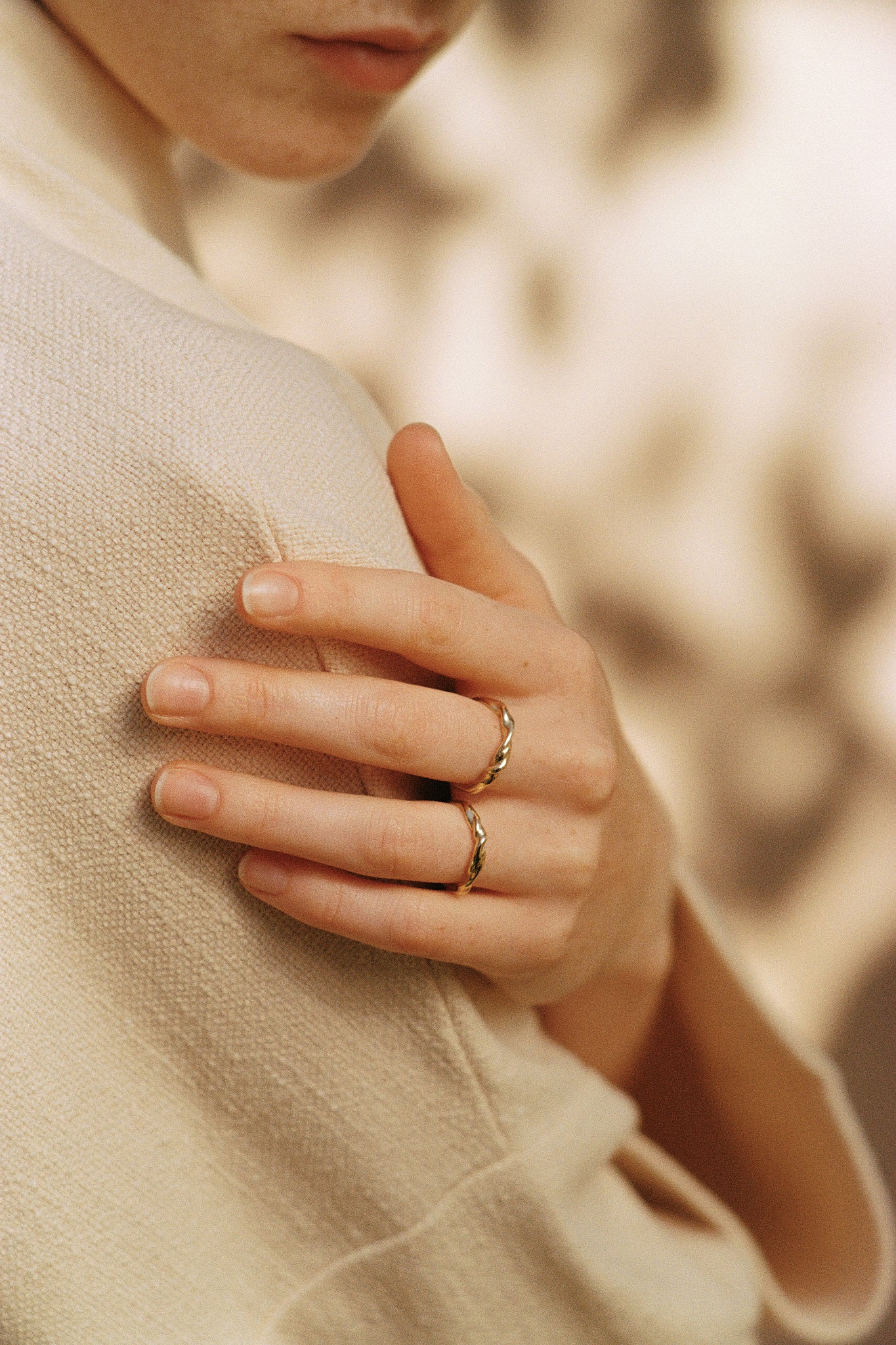 Close-up of a hand wearing AGAPI rings, handcrafted from 18k recycled gold in Basel, Switzerland.