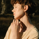 Model showcasing TOVE bracelet made of 18k recycled gold in a sunlit outdoor setting in Basel, Switzerland.
