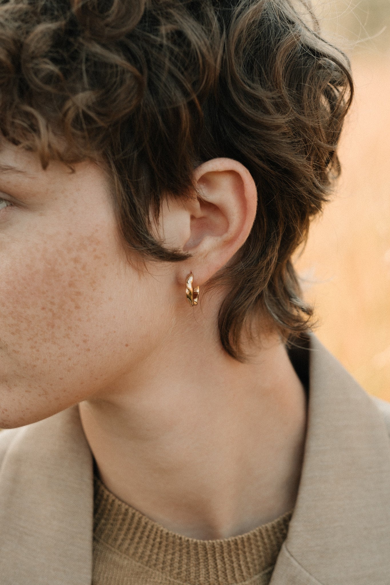 Hoops made of recycled 18k gold worn by a model in Basel, showcasing sustainable jewelry design.