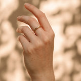 Hand wearing an AGAPI handcrafted 18k recycled gold ring, showcasing sustainable jewelry design from Basel, Switzerland.