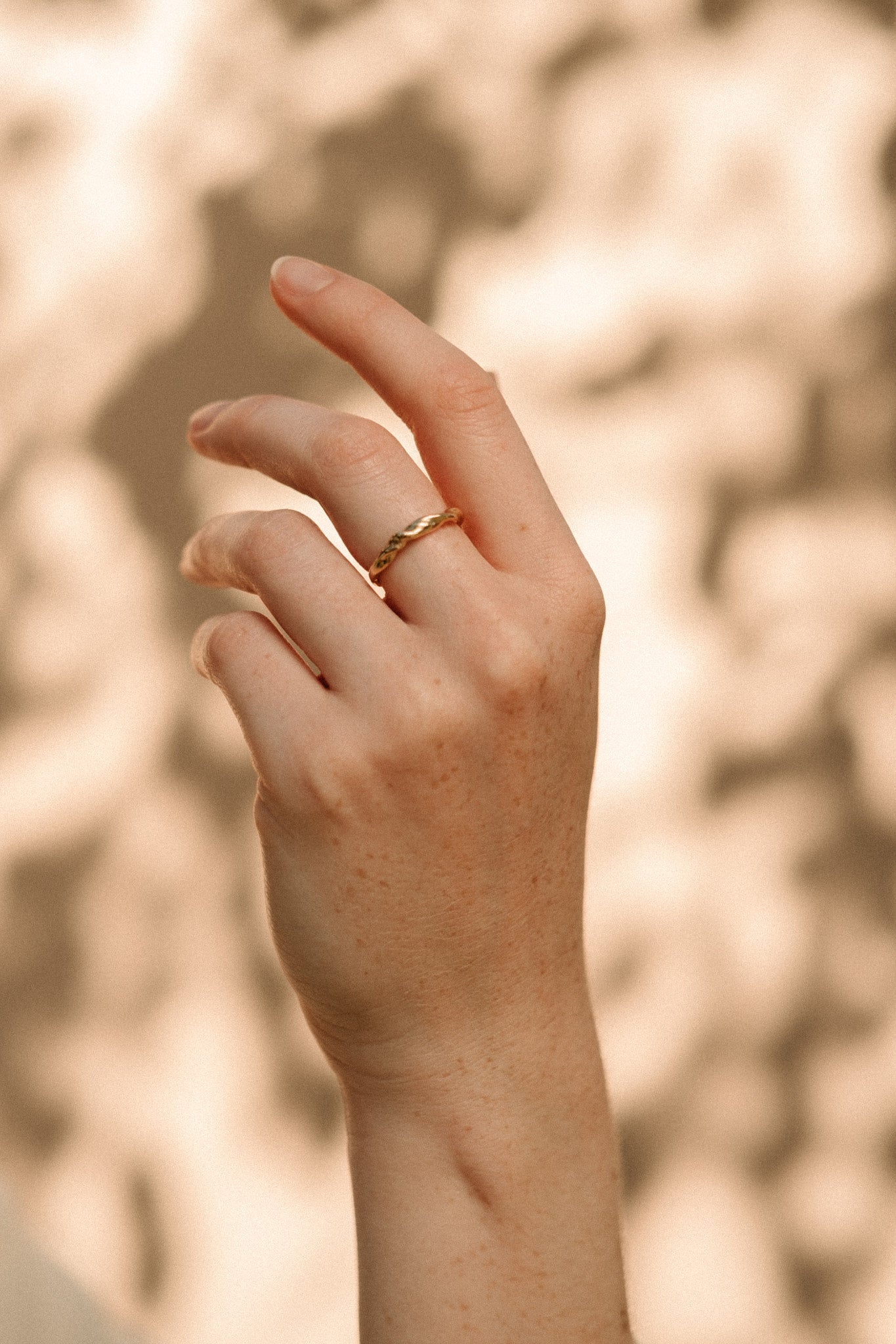 Hand wearing an AGAPI handcrafted 18k recycled gold ring, showcasing sustainable jewelry design from Basel, Switzerland.
