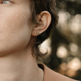 Model showcasing handcrafted 18k recycled gold LOA hoops, highlighting a natural shiny surface in Basel, Switzerland.