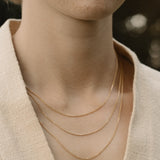 Close-up of a model showcasing layered 18k recycled gold chains, handcrafted in Basel, Switzerland.
