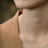 Model showcasing handcrafted TRESSE Chain in 18k recycled gold, designed in Basel Switzerland with organic materials.