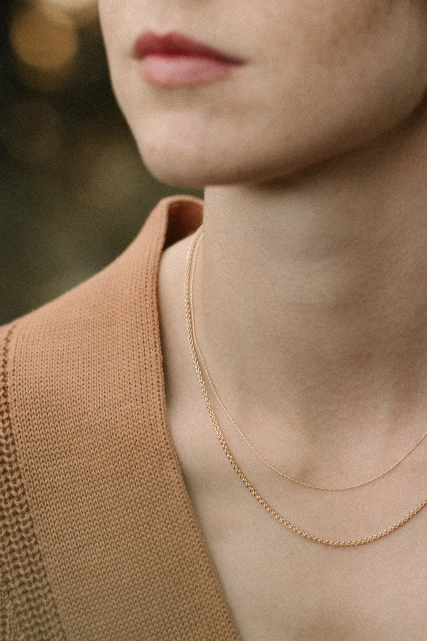 Model showcasing handcrafted TRESSE Chain in 18k recycled gold, designed in Basel Switzerland with organic materials.