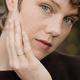 Close-up of a person wearing a handcrafted 18k recycled gold ring, showcasing natural beauty and fine details.