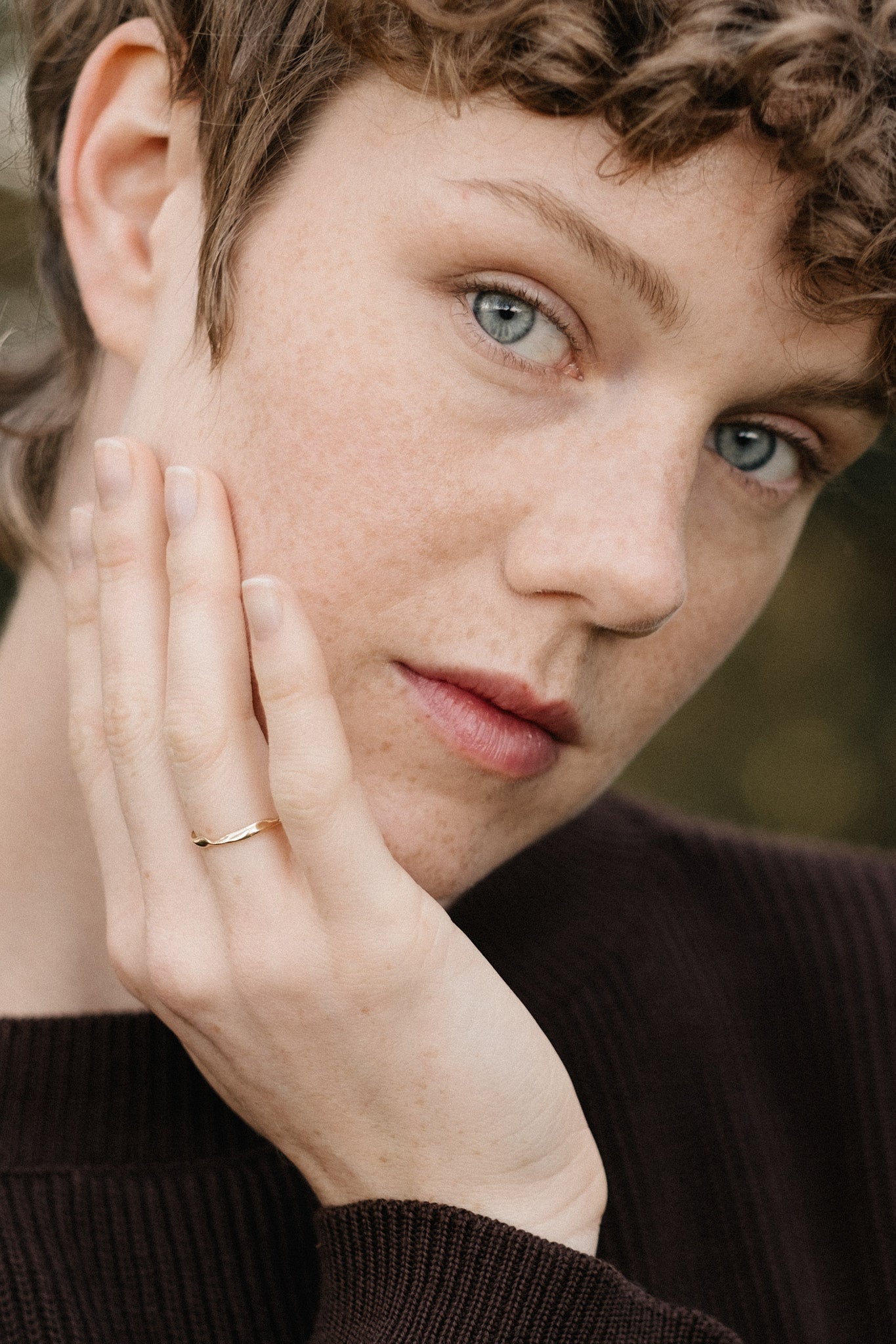 Close-up of a person wearing a handcrafted 18k recycled gold ring, showcasing natural beauty and fine details.