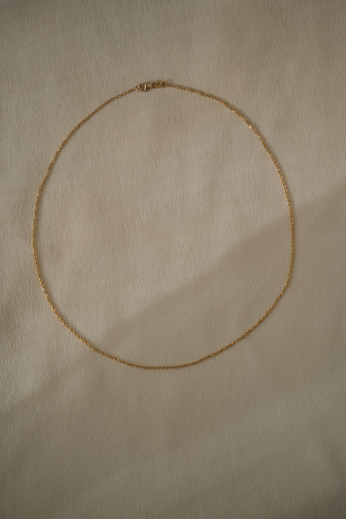 Handcrafted 18k recycled gold anchor chain from Basel, Switzerland, featuring faceted links and organic design.