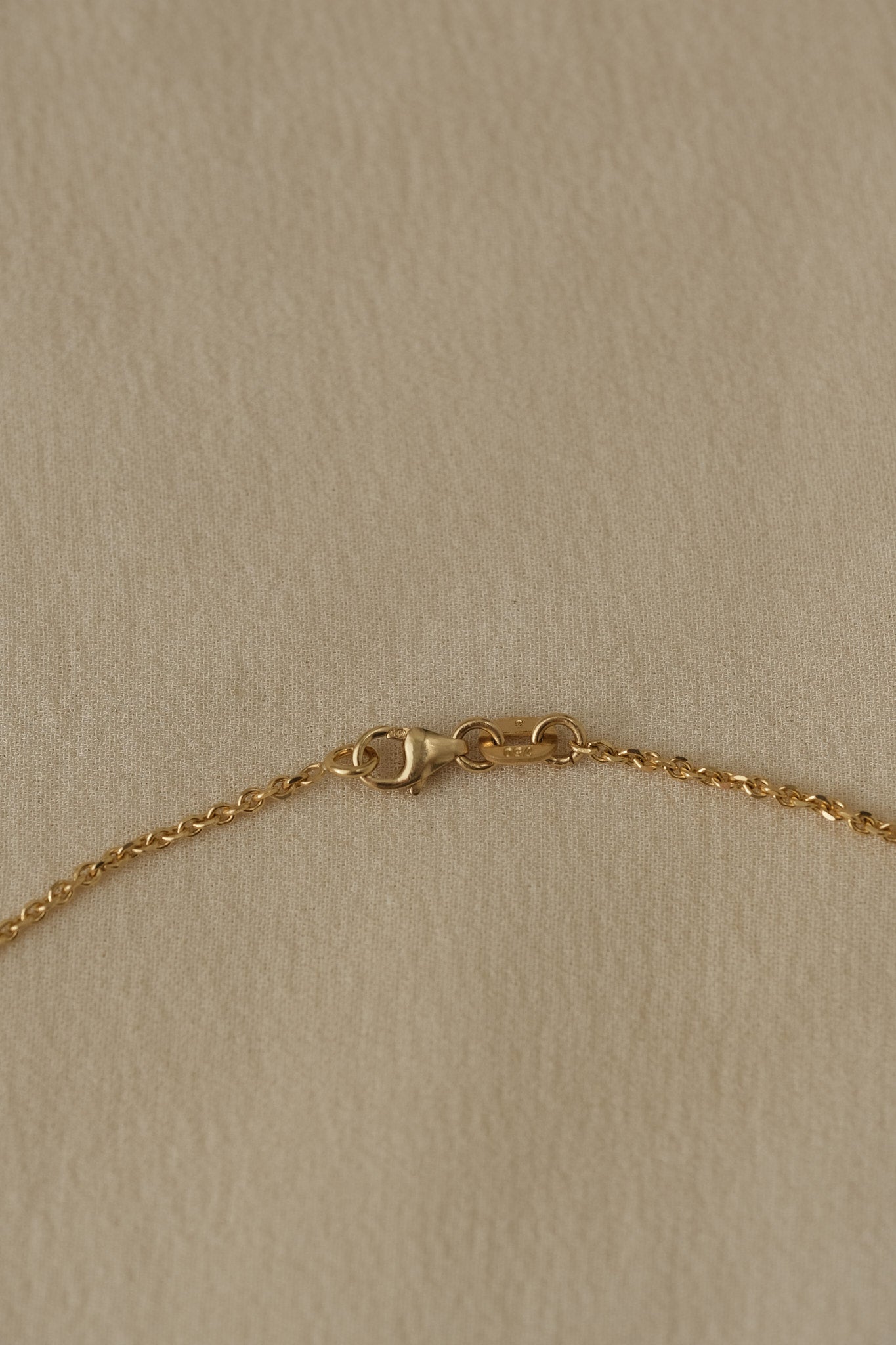 Close-up of 18k recycled gold chain clasp, handcrafted in Basel, Switzerland with organic design.