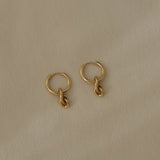 Handcrafted SINUOSA hoops made of 18k recycled gold, featuring a natural shiny surface, designed in Basel, Switzerland.