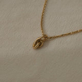 SINUOSA necklace crafted from 18k recycled gold, featuring a unique knot design, handcrafted in Basel, Switzerland.