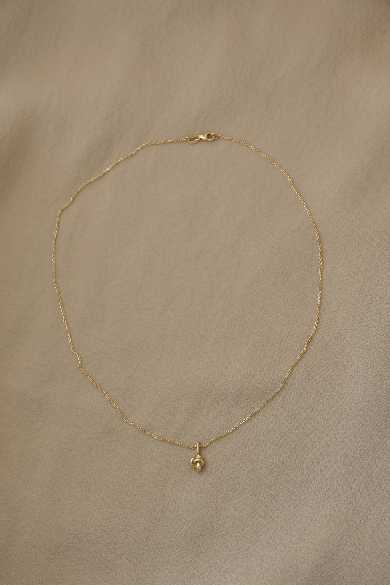 TOVE necklace in 18k recycled gold, handcrafted in Basel, featuring a delicate pendant on a thin chain.