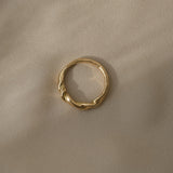 AGAPI 18k recycled gold ring handcrafted in Basel, Switzerland, featuring a natural shiny surface on a soft fabric backdrop.