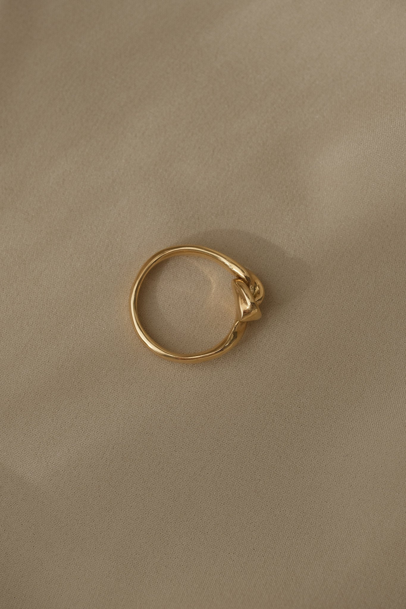 Handcrafted TWINE ring in 18k recycled gold, designed and polished in Basel, Switzerland, featuring a natural shiny surface.