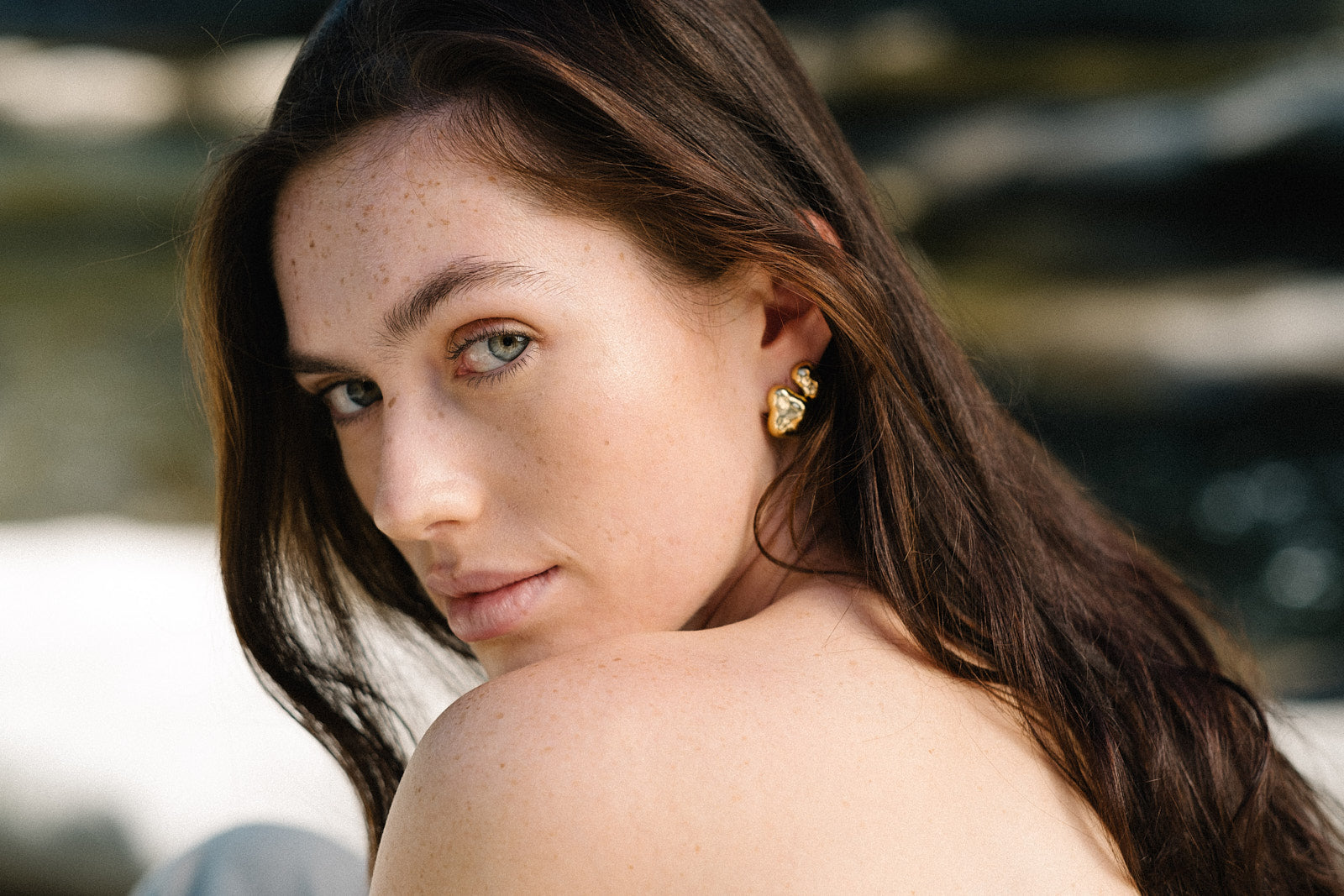 Model showcasing CLOUD earrings made of recycled silver and gold, highlighting ethical jewelry and sustainable materials.