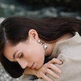 COSMA earrings in recycled silver worn by a woman, highlighting ethical, handmade, and sustainable jewelry.