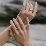 Hands adorned with ethical handmade rings in 18k gold-plated recycled silver, showcasing sustainable jewelry.
