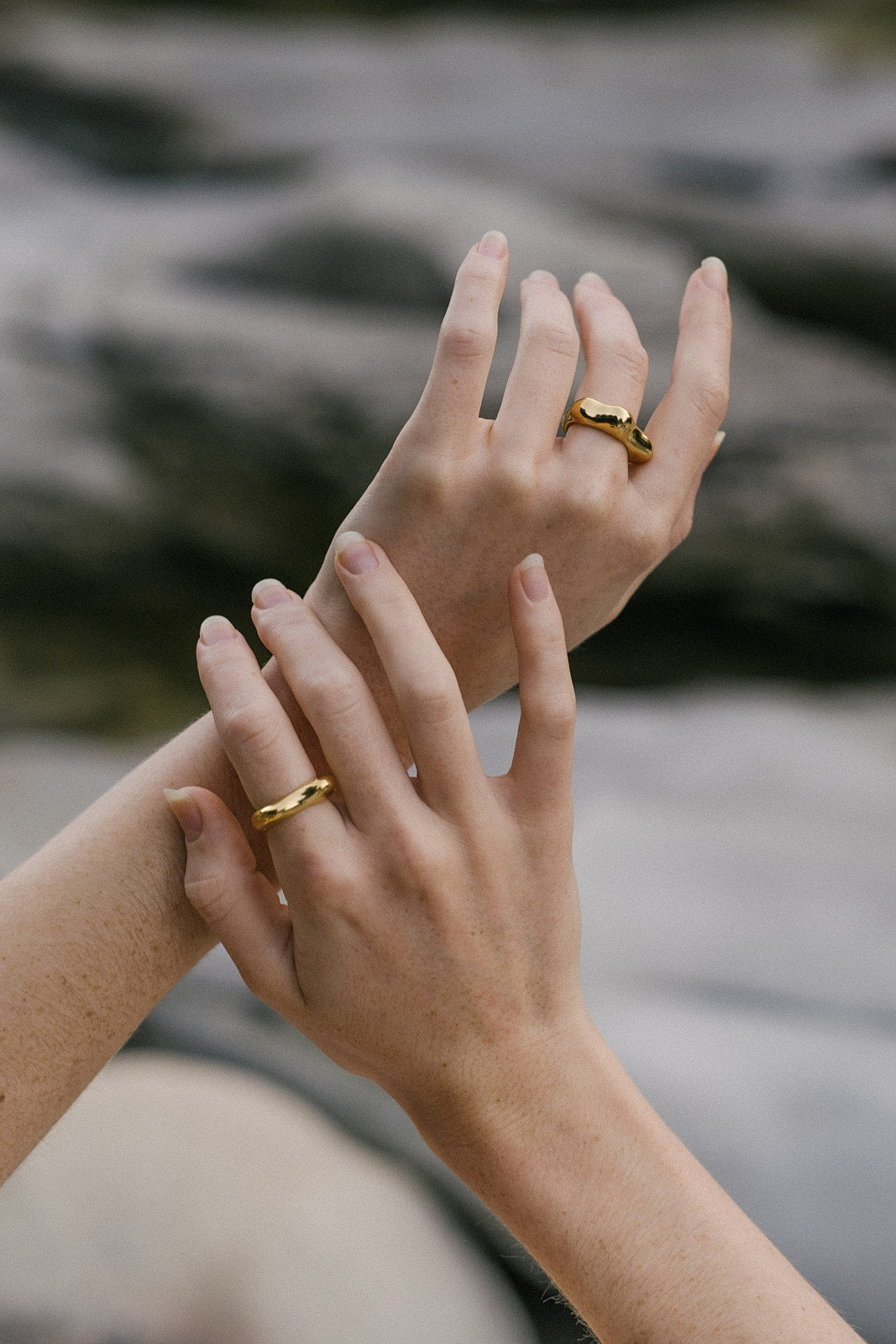 Hands adorned with ethical handmade rings in 18k gold-plated recycled silver, showcasing sustainable jewelry.