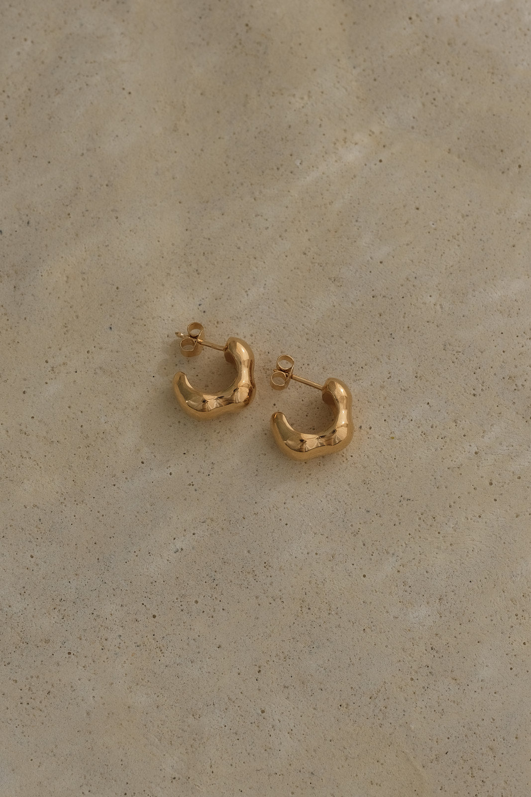 Handmade FLUID earrings in recycled gold, ethical jewelry crafted in Germany, featuring a natural shiny surface.