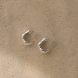 Fluid earrings made of recycled silver, showcasing sustainable and ethical craftsmanship in a natural shiny finish.