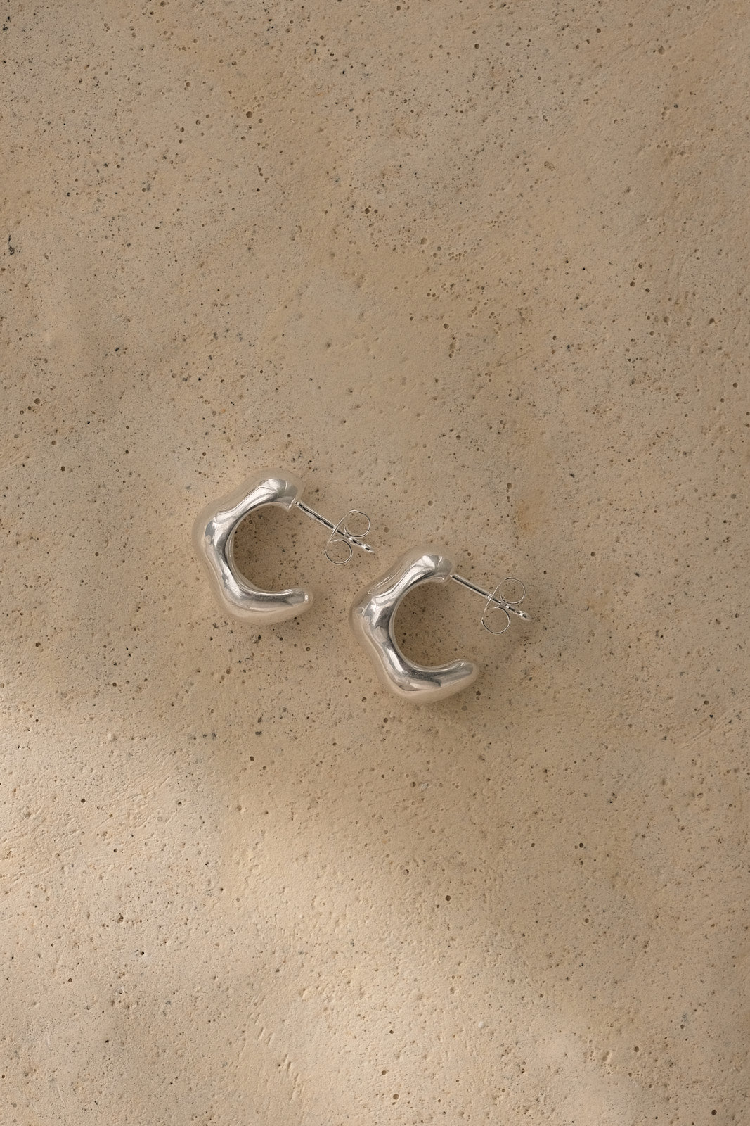 Fluid earrings made of recycled silver, showcasing sustainable and ethical craftsmanship in a natural shiny finish.