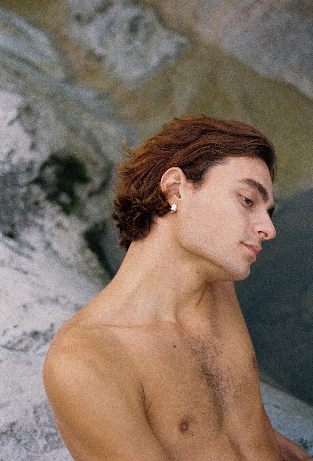 Profile view of a man wearing ethical FLUID earrings made of recycled gold and silver, showcasing handmade craftsmanship.