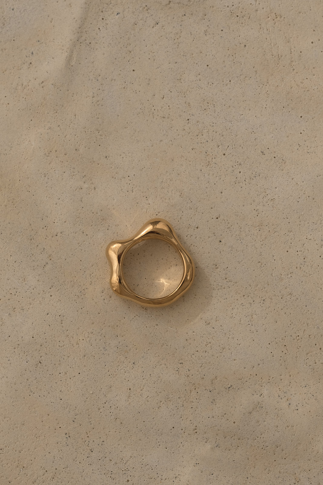 Ethical handmade FLUID ring in 18k gold-plated recycled silver on a neutral background.