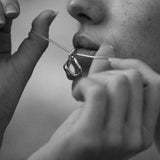 Woman holding FUSE necklace made from recycled silver, showcasing ethical handmade jewelry.