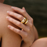A close-up of a hand wearing a HALO ring made of 18k gold-plated recycled silver, highlighting its shiny finish.