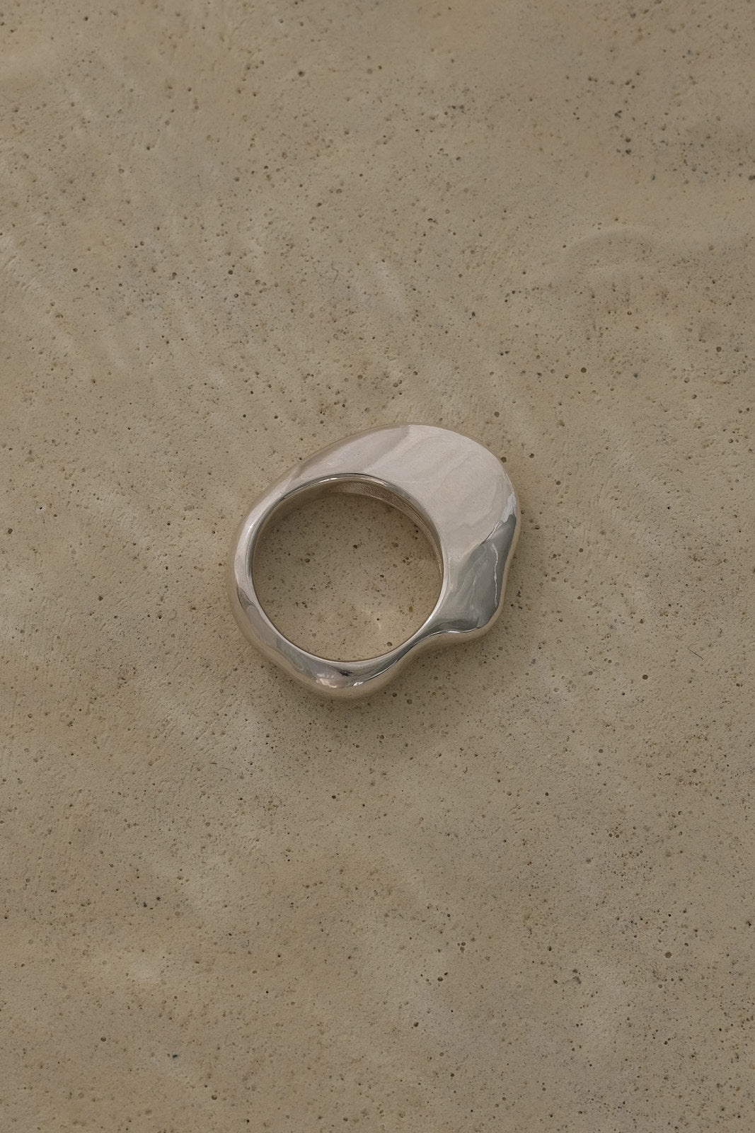 HALO ring in recycled 925 silver, showcasing a natural shiny surface on a subtle textured background.