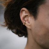 MISMO earcuff in gold on model's ear, showcasing ethical jewelry made from recycled gold and silver.
