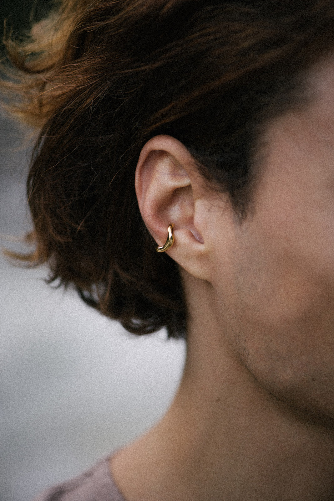 MISMO earcuff in gold on model's ear, showcasing ethical jewelry made from recycled gold and silver.