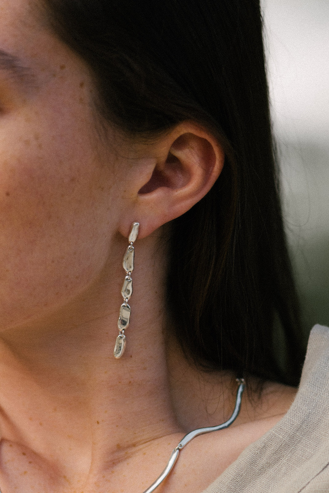 Handmade MURMUR earrings in recycled silver, showcasing ethical jewelry with a natural shiny finish.