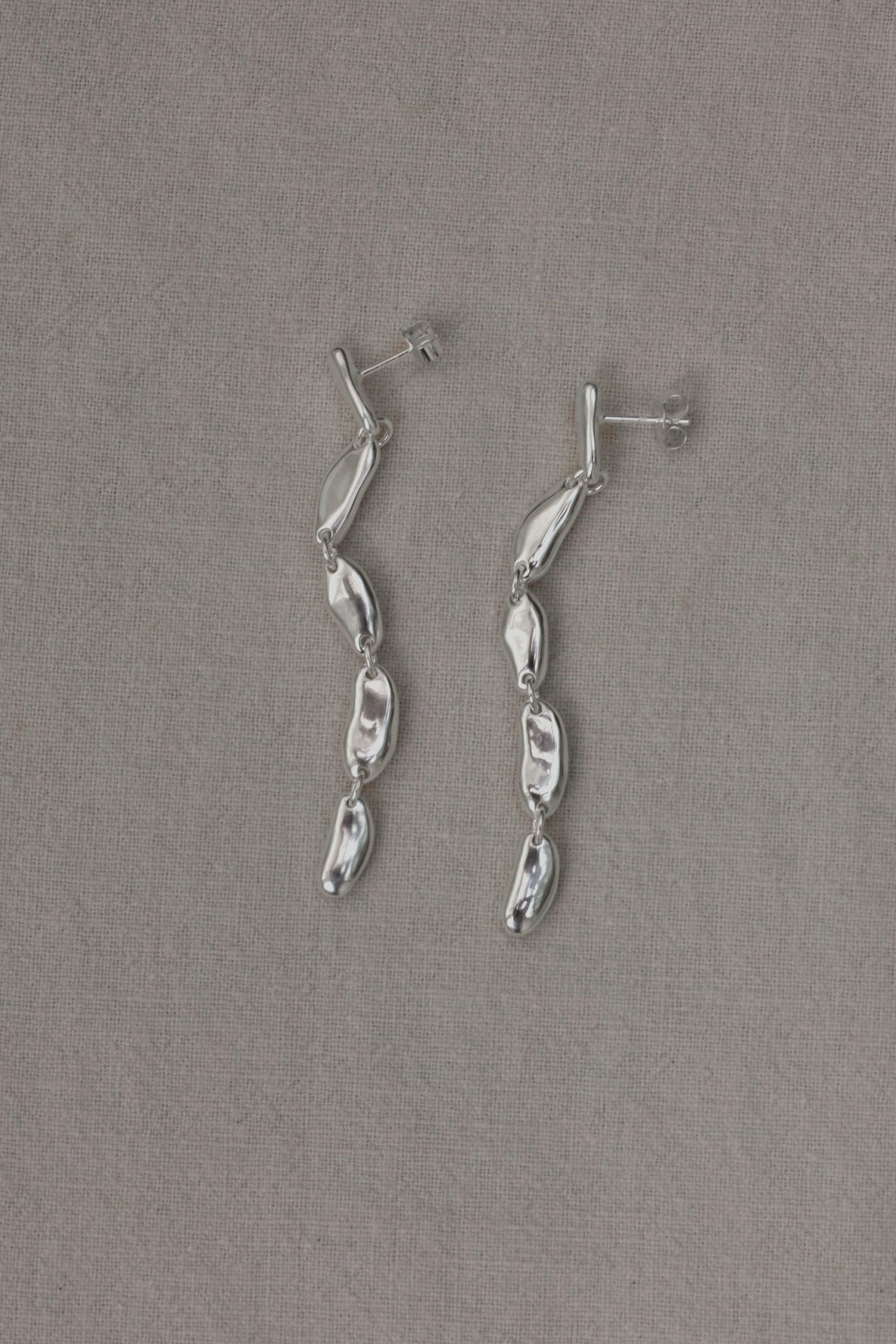 MURMUR earrings made of 925 recycled silver, showcasing an ethical and handmade design with a shiny surface.