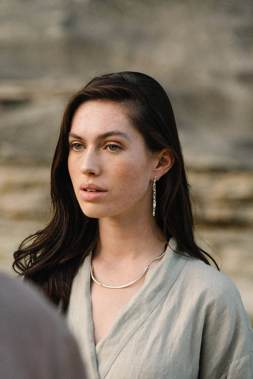 Model wearing MURMUR earrings made of recycled silver, showcasing sustainable, ethical jewelry with a handmade touch.