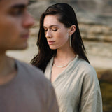 MURMUR earrings worn by a woman in a natural setting, highlighting ethical jewelry craftsmanship and sustainable materials.