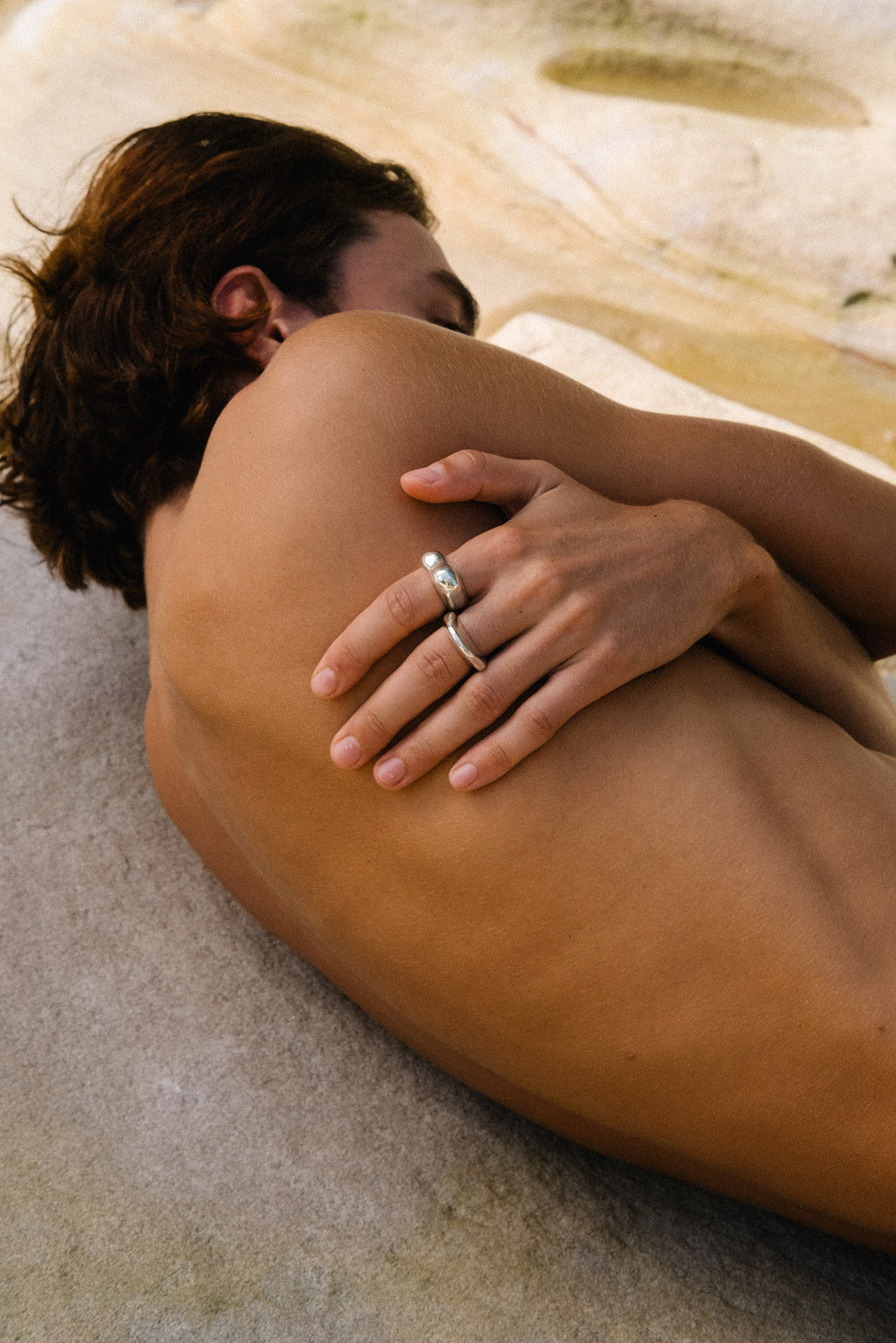 Close-up of hand wearing MUSA ring on bare shoulder, showcasing ethical jewelry made from recycled materials.