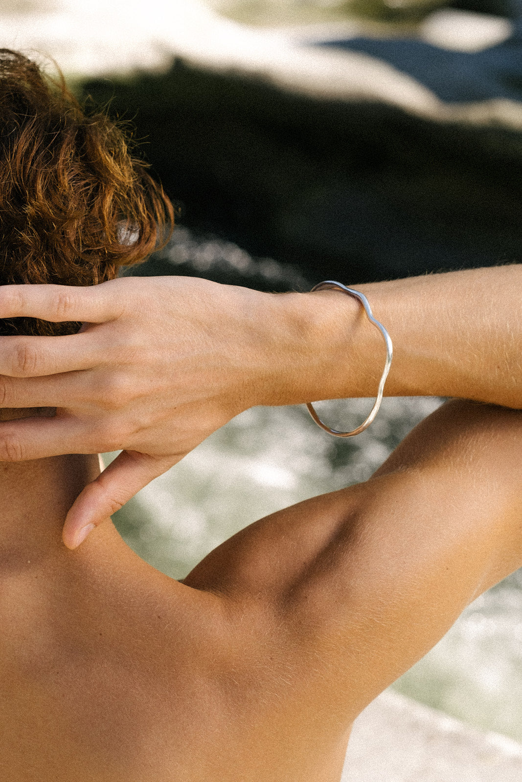 Handmade PLACID bangle in recycled silver, worn on a model's wrist, showcasing sustainable ethical jewelry.