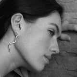 Model showcasing PLACID earrings, handmade from recycled gold and silver, emphasizing ethical jewelry craftsmanship.