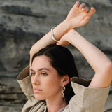 Model wearing PLACID earrings made of recycled silver, showcasing sustainable and ethical handmade jewelry.