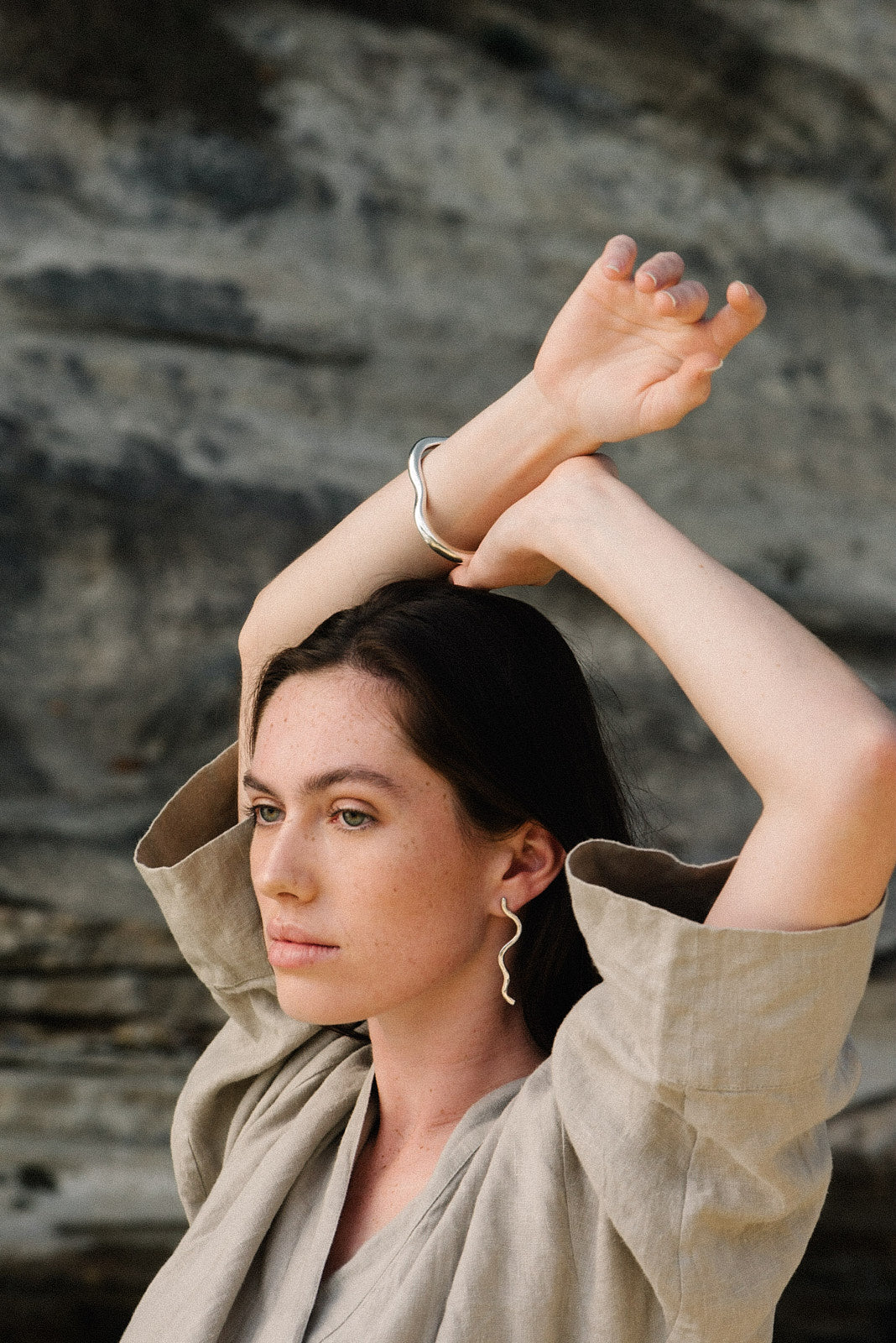 Model wearing PLACID earrings made of recycled silver, showcasing sustainable and ethical handmade jewelry.