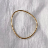 LOON bangle made of 18k recycled gold, handcrafted in Basel, Switzerland, featuring an organic design with a semi-shiny finish.